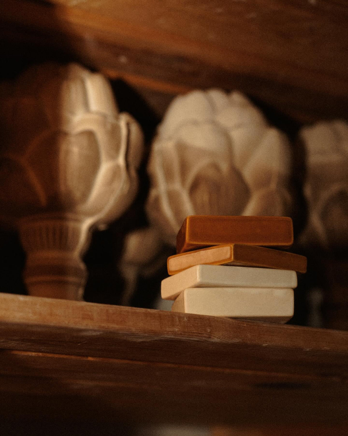 Gotowe podstawki AUURA ułożone na drewnianej belce w pracowni