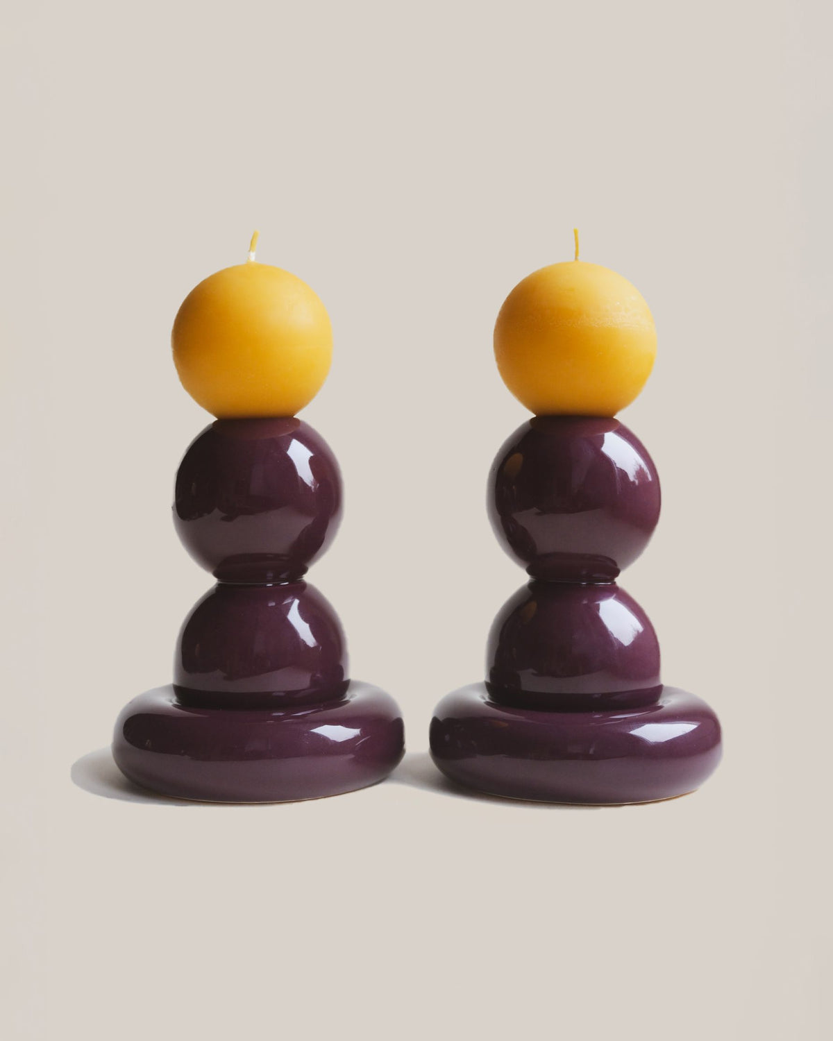 Fioletowe ceramiczne świeczniki ADAM i EWA PLUM z żółtymi świeczkami